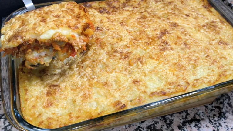 Porción de pastel de patatas con carne picada y queso gratinado en fuente de horno