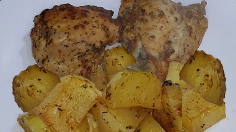 Plato de pollo marinado con hierbas provenzales acompañado de patatas al horno doradas