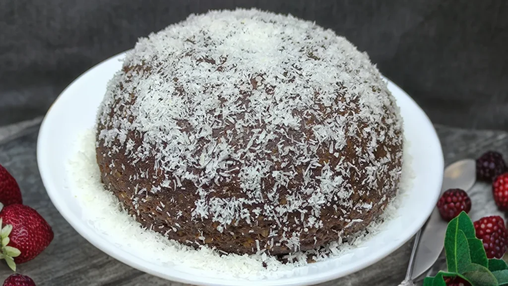 Bola energética saludable hecha de avena, dátiles y semillas, con una textura compacta y natural sobre un fondo neutro.