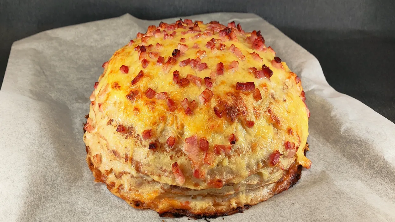 Crepes dorados rellenos de tiras de bacon crujiente y queso fundido servidos en un plato oscuro.