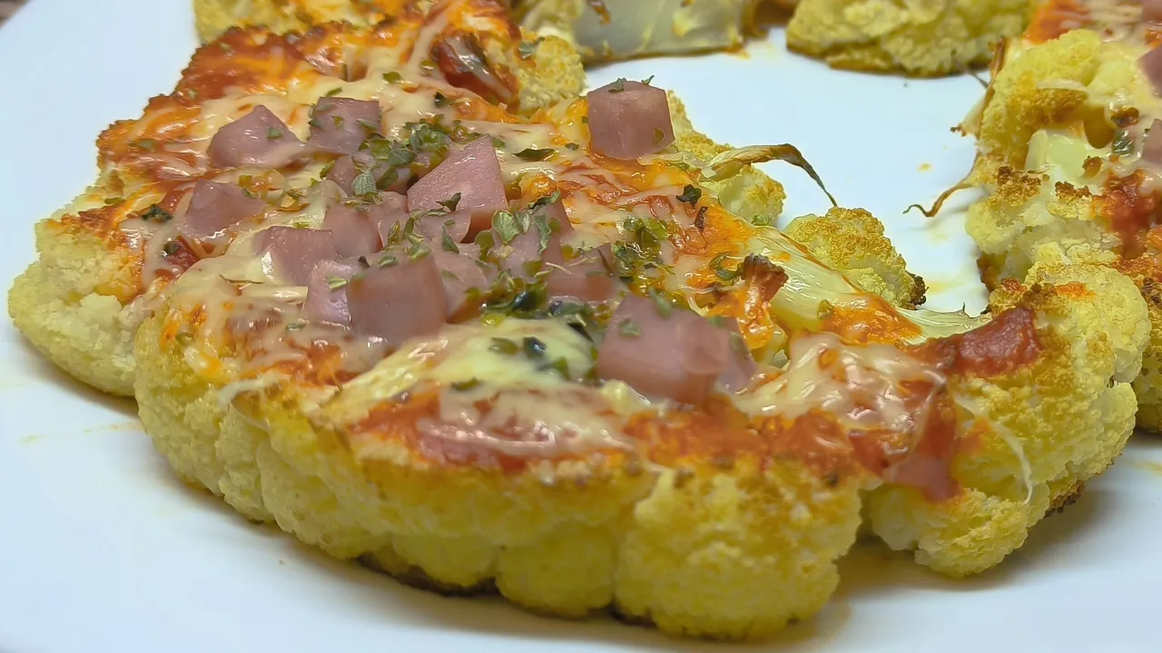 Pizza hecha con base de coliflor casera, cubierta de queso fundido y hierbas, receta de Cocina con Flory