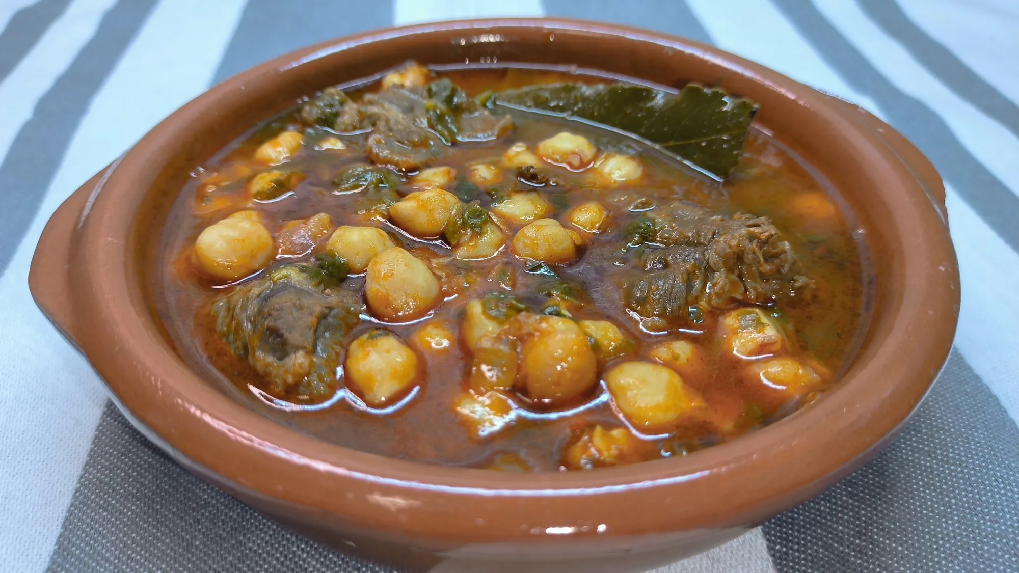 Plato de garbanzos con grelos y morcillo casero en un recipiente, receta tradicional de Cocina con Flory