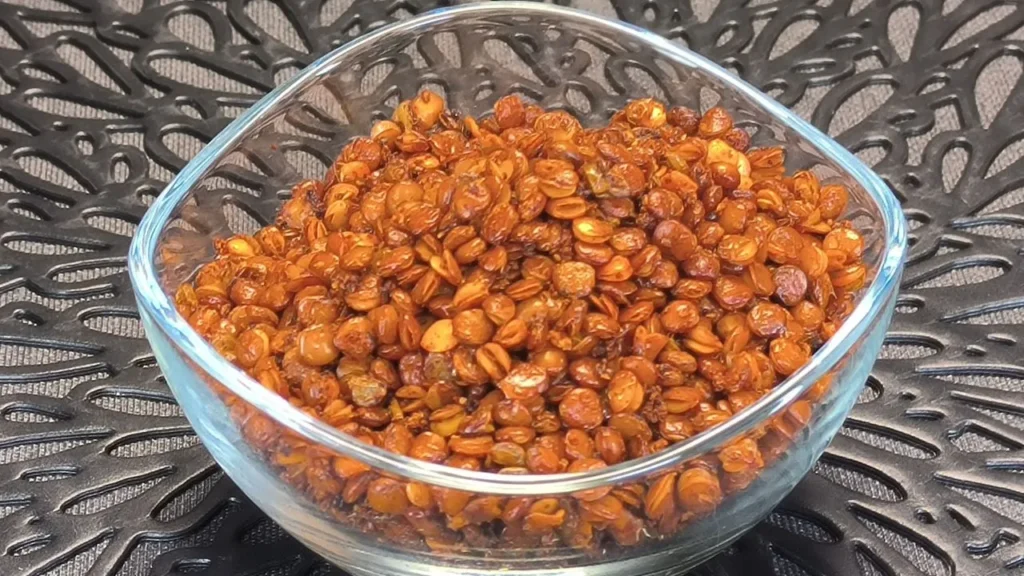 Lentejas cocidas sazonadas con especias dorándose en la cesta de una freidora de aire para un snack crujiente.