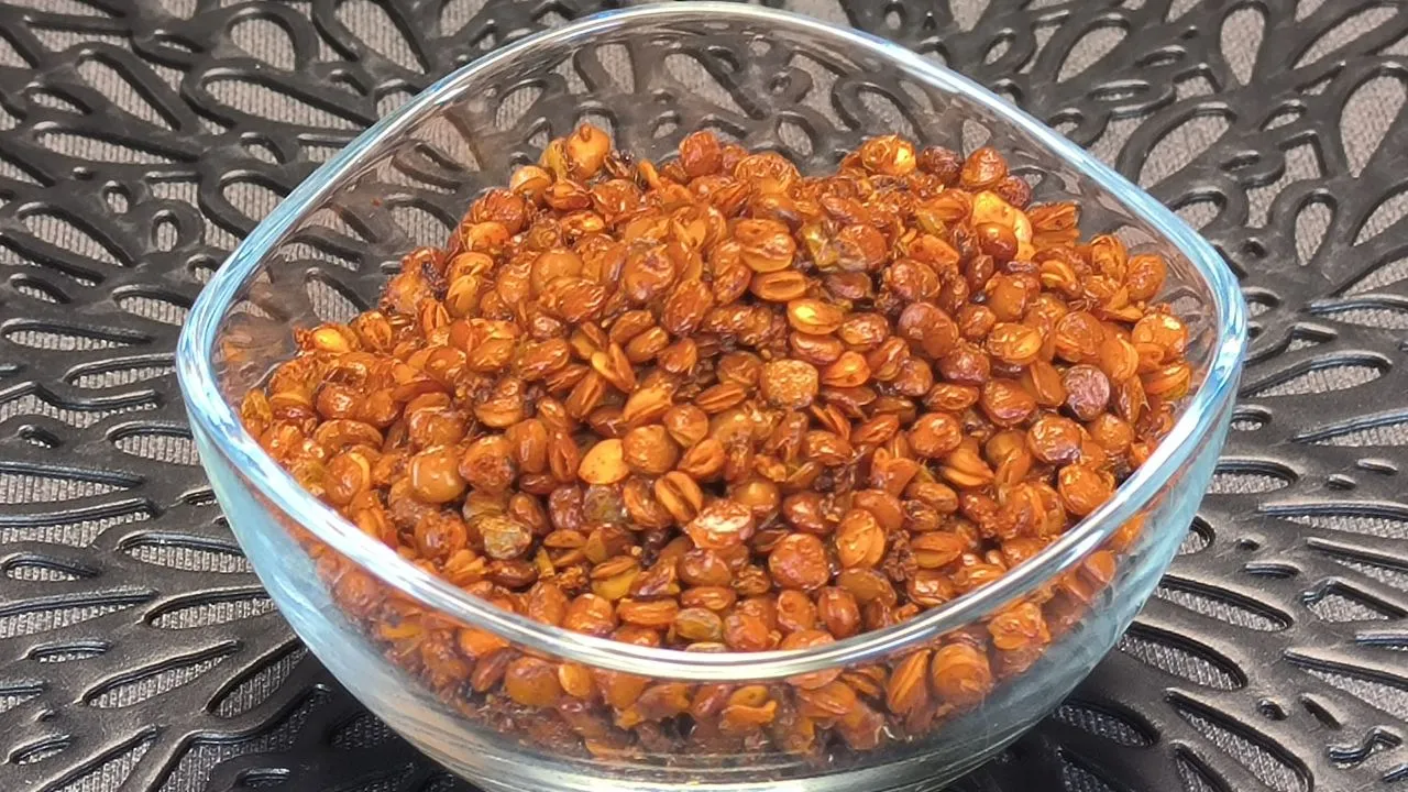 Lentejas cocidas sazonadas con especias dorándose en la cesta de una freidora de aire para un snack crujiente.