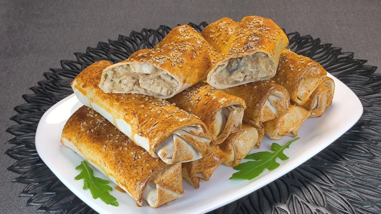 Rollitos de pollo y champiñones con semillas de sésamo cocinados en freidora de aire, presentados en un plato blanco.